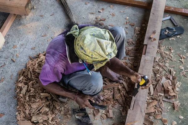 Carpenter working in traditional manual carpentry shop in a third world country.