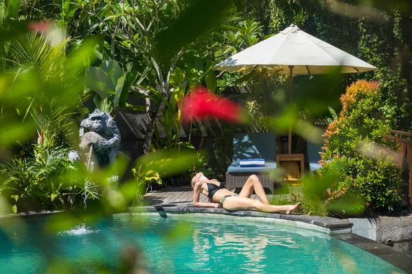 Smyslná mladá žena relaxující ve venkovních lázních nekonečný bazén obklopen svěží tropické zeleně Ubud, Bali. — Stock fotografie