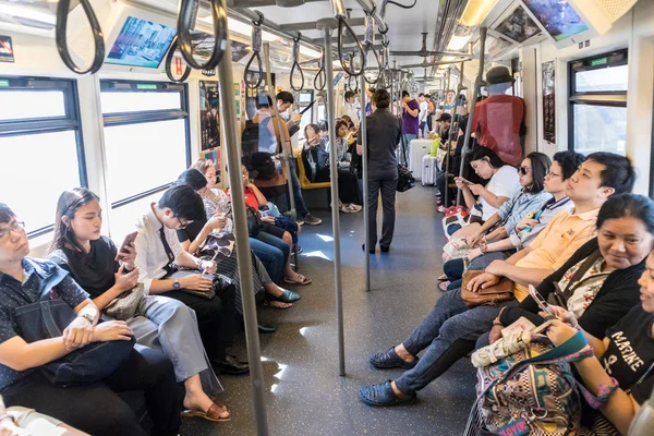 Passenegers használ-uk mozgatható telefon berendezés míg ingázás város metróval, Bangkok, Thaiföld — Stock Fotó