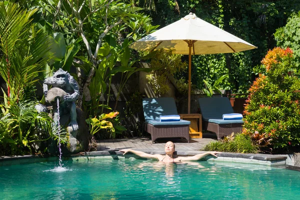 Sinnliche junge Frau entspannt sich im Outdoor-Wellness-Infinity-Pool inmitten des üppigen tropischen Grüns von Ubud, Bali. — Stockfoto
