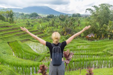 Relaxed female tracker enjoying pure nature at beautiful green rice fields on Bali.