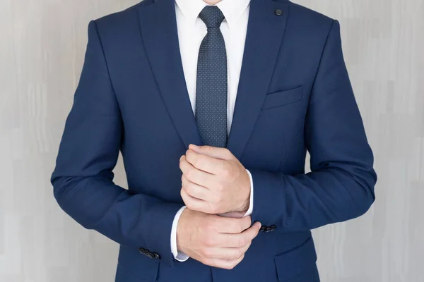 Torso av anonyma affärs man bär vackra fashionabla klassiska marinblå kostym mot grå backgound. — Stockfoto