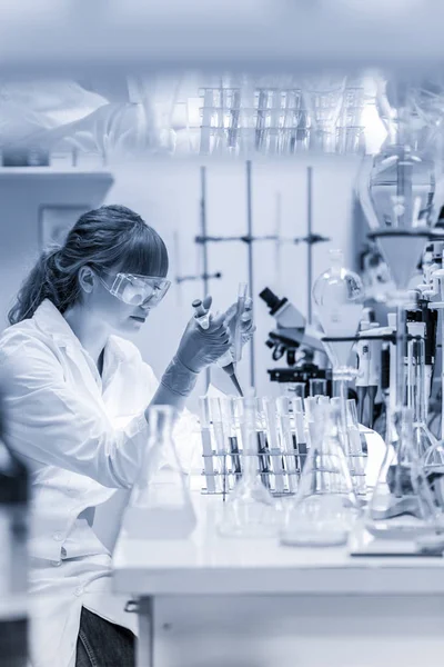 Jovem cientista pipetando em laboratório de ciências da vida. — Fotografia de Stock