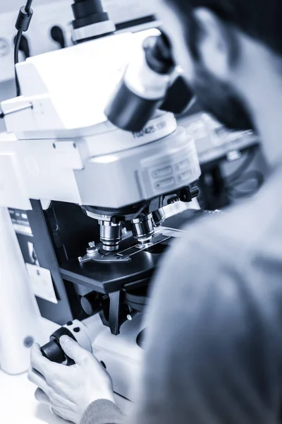 Bilim adamı floresan mikroskobu üzerinde mikroskop yapıyor.. — Stok fotoğraf