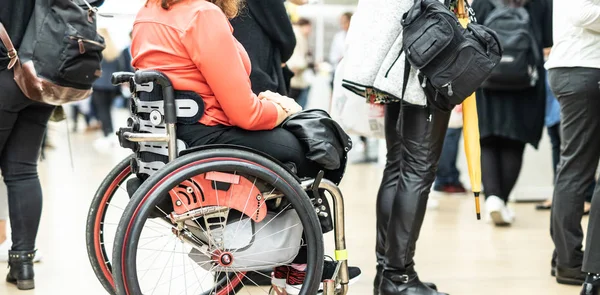 Close up de mulher hanicapped irreconhecível em uma fila de cadeira de rodas na fila para executar tarefas cotidianas. — Fotografia de Stock