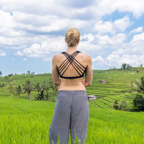 Entspannte, sportliche Frau genießt Natur pur auf schönen grünen Reisfeldern auf Bali. — Stockfoto