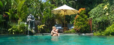 Mutlu çift açık spa sonsuzluk yüzme havuzunda rahatlarken öpüşme tropik yeşillikler Ubud, Bali ile çevrili. Lüks spa ve wellness tatil geri çekilme kavramı
