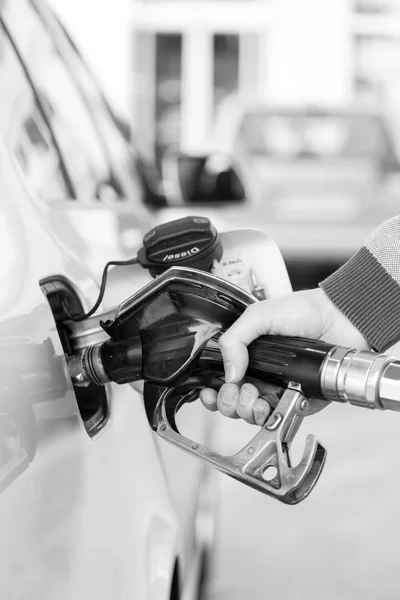 Närbild av mans handpumpning bensin bränsle i bilen på macken. — Stockfoto