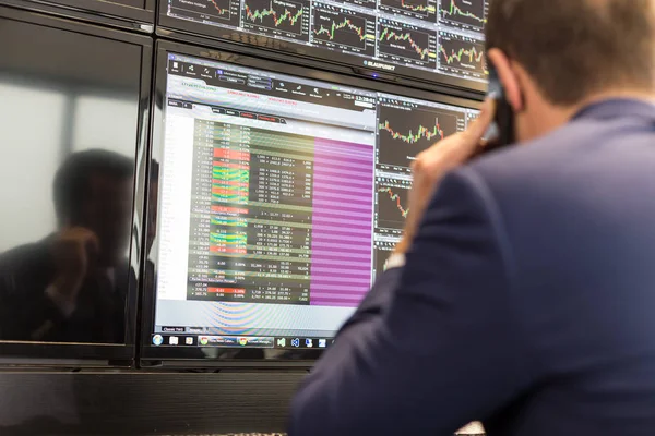 Stock broker trading online, talking on mobile phone. — Stock Photo, Image