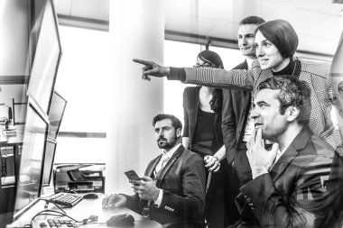 Şirket ofisindeki bilgisayar ekranlarında ticaret verilerine bakan başarılı iş ekibi.