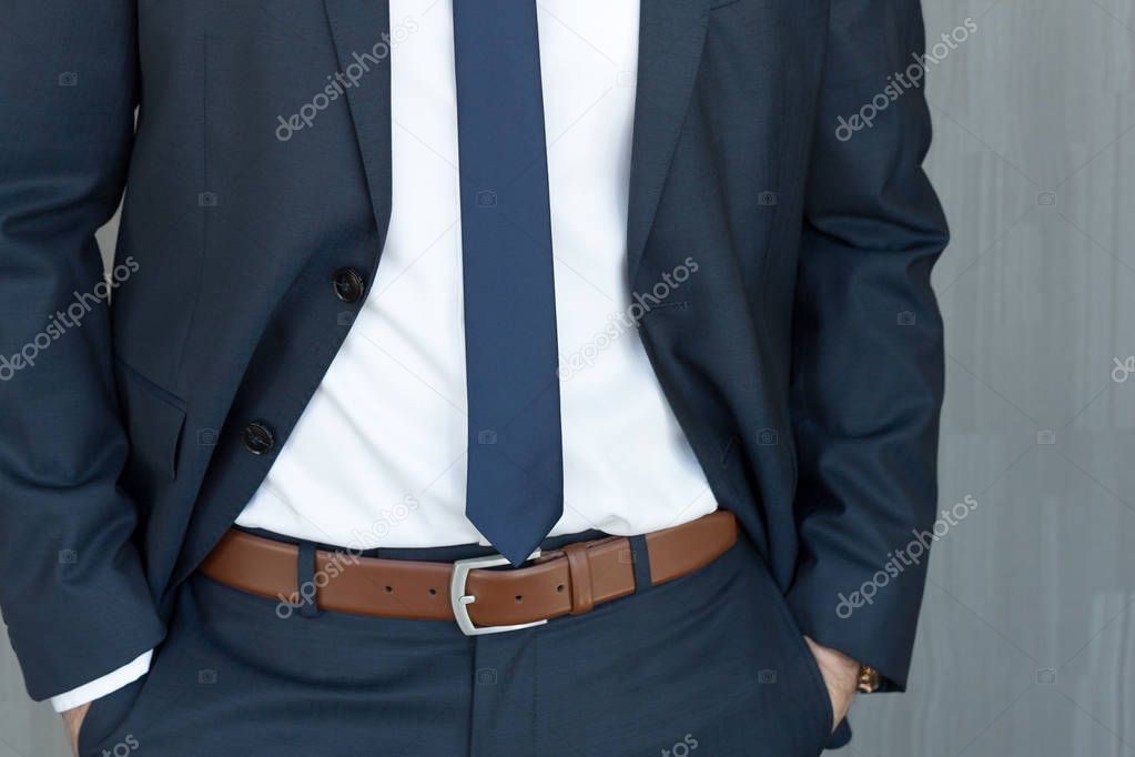Torso of a businessman standing with hands clenched in middle position in a classic navy blue suit.