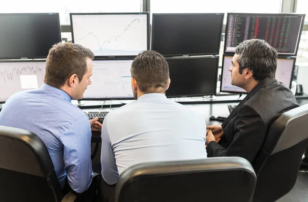 Business team brainstorming durante il controllo dei dati sugli schermi del computer . — Foto Stock