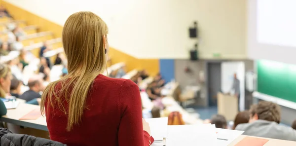 Studentin besucht Vortragsworkshop der Fakultät und macht sich Notizen. — Stockfoto