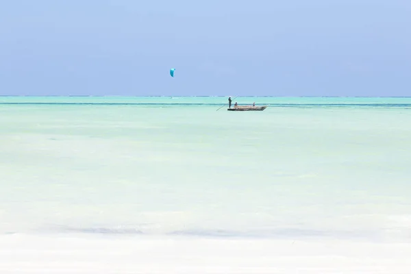 Fiskebåt och en kite Surfer på bilden perfekt vit sandstrand med turkos blått hav, Paje, Zanzibar, Tanzania. — Stockfoto