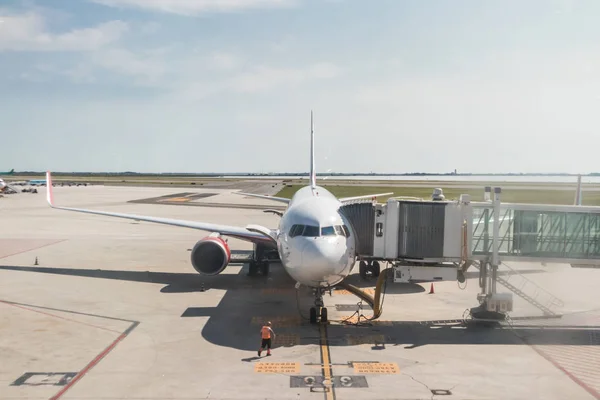 Avião de passageiros comercial moderno estacionado no edifício do terminal do aeroporto — Fotografia de Stock