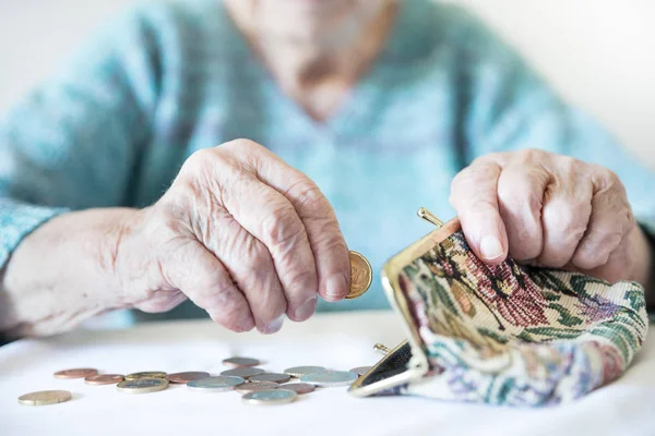 Detailliertes Nahaufnahme-Foto von nicht wiederzuerkennenden älteren Frauen, die nach dem Bezahlen von Rechnungen noch Münzen aus der Rente in ihrer Brieftasche zählen. — Stockfoto