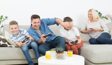 Happy young family playing videogame On TV. clipart