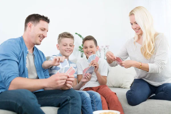 Jovem família feliz jogando jogo de cartas em casa. — Fotografia de Stock