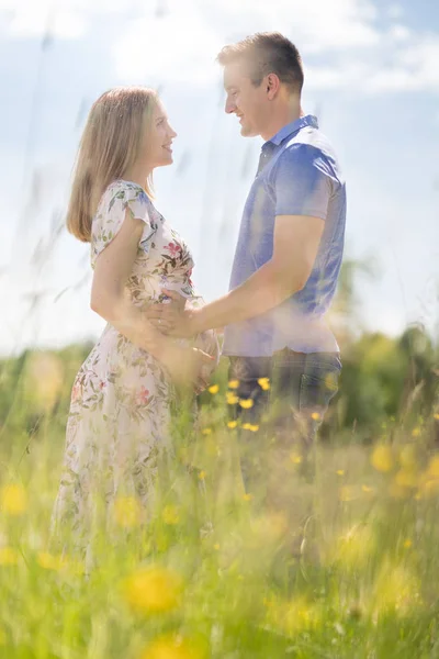 Jong gelukkig zwanger paar knuffelen in de natuur. — Stockfoto