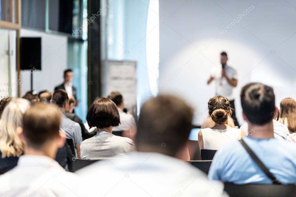 Male business speaker giving a talk at business conference event.