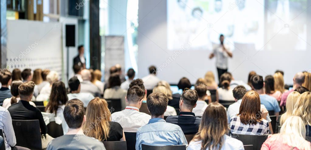 Male business speaker giving a talk at business conference event.