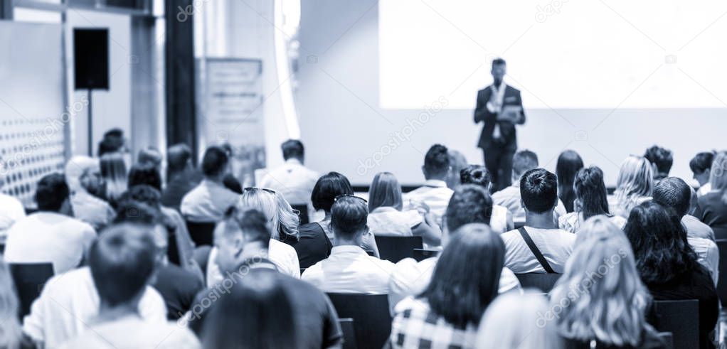 Male business speaker giving a talk at business conference event.