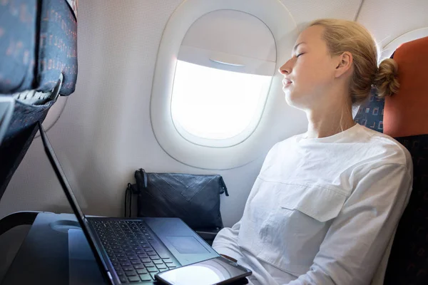 Втомлена ділова жінка застрягла на літаку під час своєї ділової поїздки прокидається завдання . — стокове фото