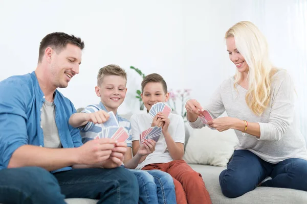 Jovem família feliz jogando jogo de cartas em casa. — Fotografia de Stock