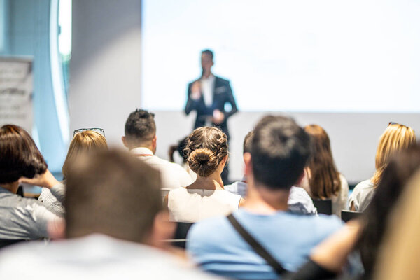 Male business speaker giving a talk at business conference event.