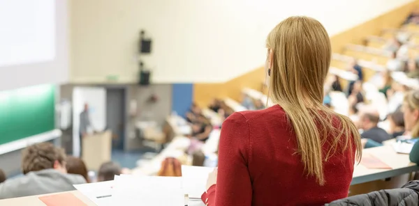 Audience in the lecture hall. Female student making notes. — Stock Photo, Image