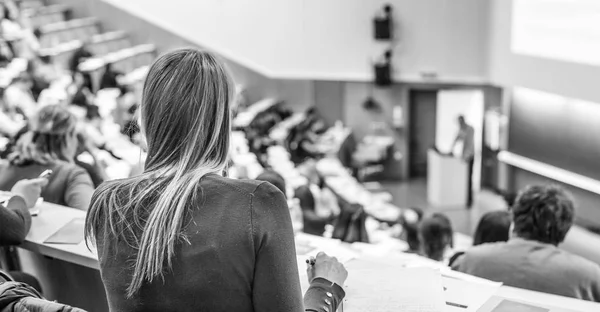 Audience in the lecture hall. Female student making notes. — Stock Photo, Image