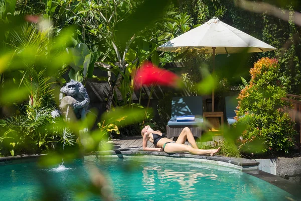 Sensuell ung kvinna avkopplande i utomhus spa infinity pool omgiven av frodig tropisk grönska i Ubud, Bali. — Stockfoto