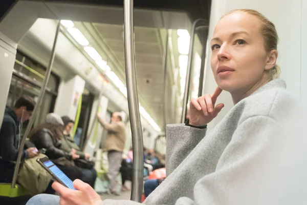 Όμορφη ξανθιά γυναίκα χρησιμοποιώντας έξυπνο τηλέφωνο, ενώ ταξιδεύετε με το μετρό μέσα μαζικής μεταφοράς. — Φωτογραφία Αρχείου