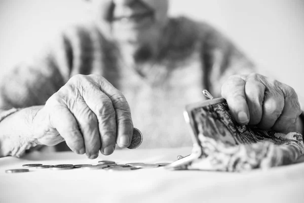 Szczegółowe zdjęcie zbliżenie nierozpoznawalnych starszych womans ręce licząc Pozostałe monety z emerytury w portfelu po zapłaceniu rachunków. Czarno-biały obraz. — Zdjęcie stockowe