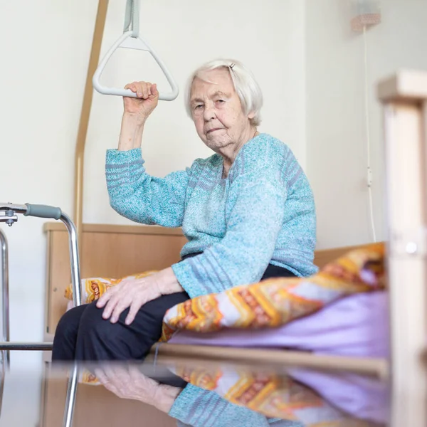 Пожилая женщина 96 лет, сидящая на медицинской кровати в хосписе . — стоковое фото