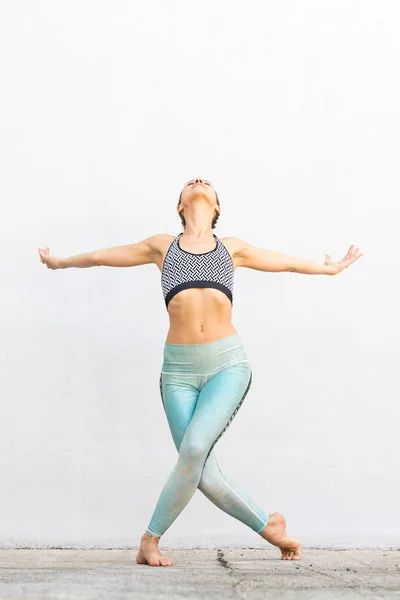 Apto menina ativa desportiva na moda sportswear fazendo ioga exercício de fitness na frente da parede cinza, esportes ao ar livre, estilo urbano — Fotografia de Stock