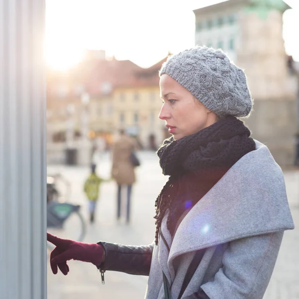 Casual woman buying public transport tickets on city urban vedning machine on cold winter day. — Stock Photo, Image