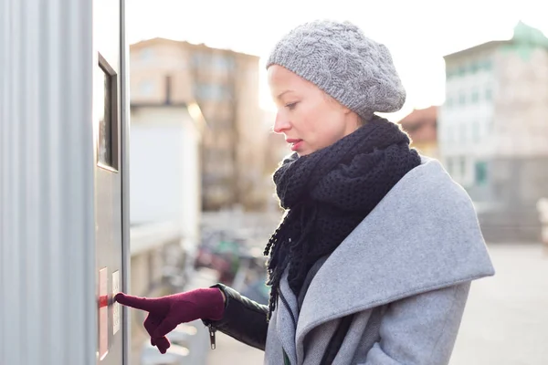 Casual woman buying public transport tickets on city urban vedning machine on cold winter day. — Stock Photo, Image