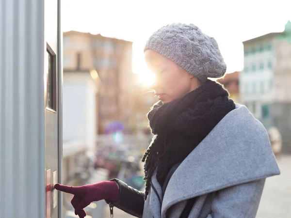 Casual woman buying public transport tickets on city urban vedning machine on cold winter day. — Stock Photo, Image