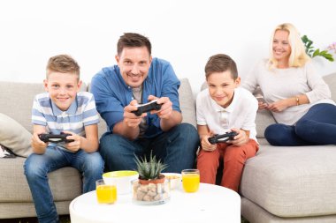 Mutlu genç aile Tv'de video oyunu oynuyor.