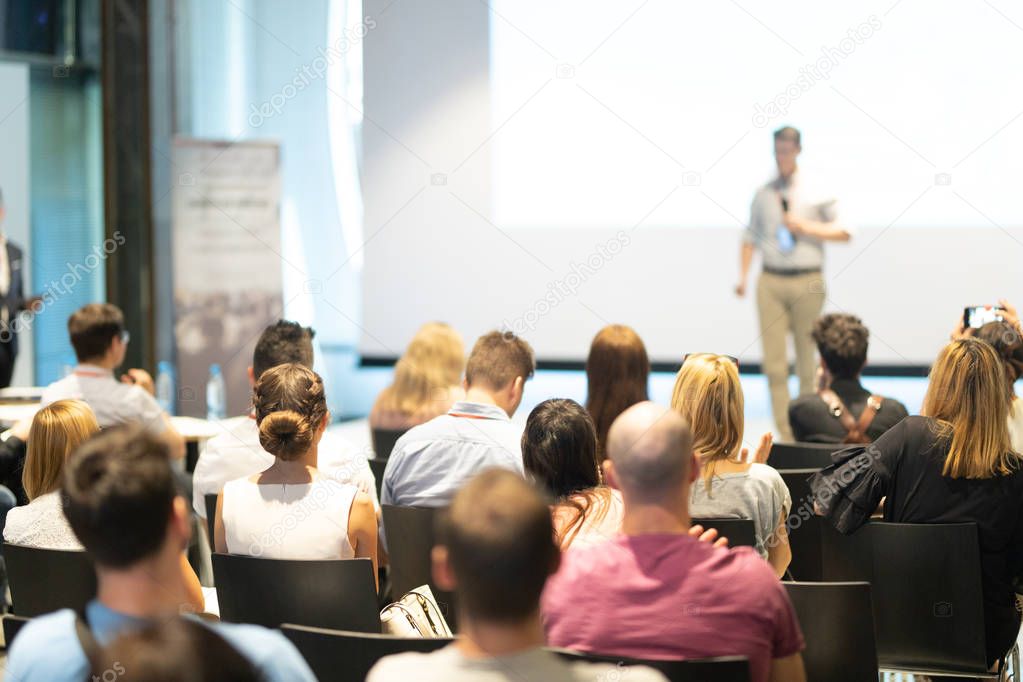 Male business speaker giving a talk at business conference event.