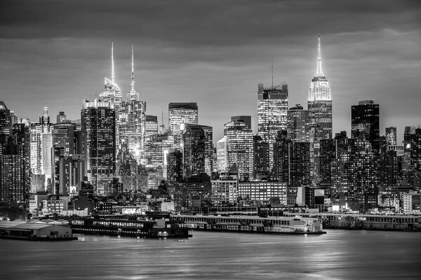 West New York City midtown Manhattan skyline panorama view from Boulevard East Old Glory Park over Hudson River at night. Black and white image.