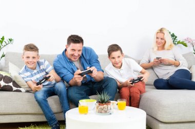 Mutlu genç aile Tv'de video oyunu oynuyor.