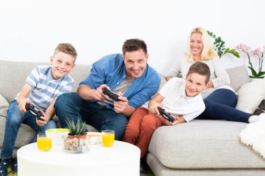 Mutlu genç aile Tv'de video oyunu oynuyor.