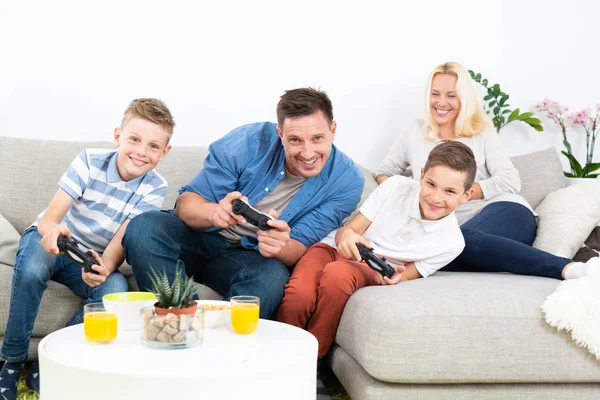 Happy young family playing videogame On TV.