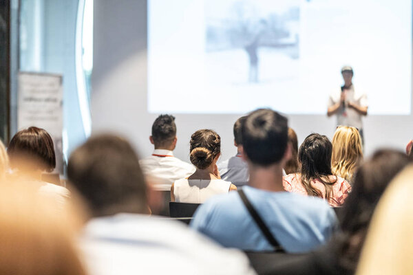 Male business speaker giving a talk at business conference event.