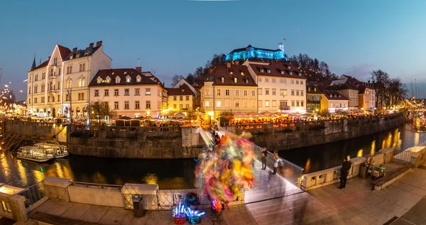 View of lively river Ljubljanica bank in old city center decorated with Christmas lights at dusk. Old medieval Ljubljana cstle on the hill obove the city. Ljubljana, Slovenia, Europe — Stock Photo, Image