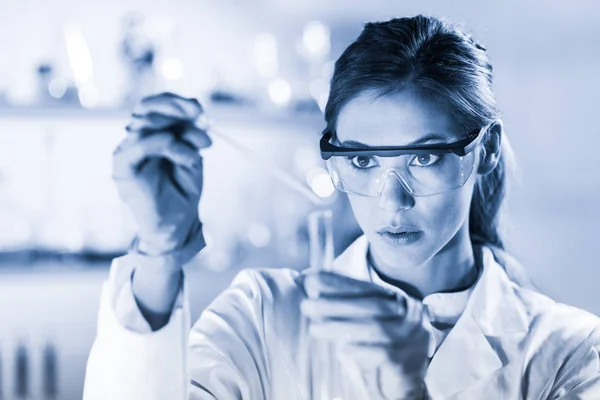 Jovem cientista pipetando em laboratório de ciências da vida. — Fotografia de Stock