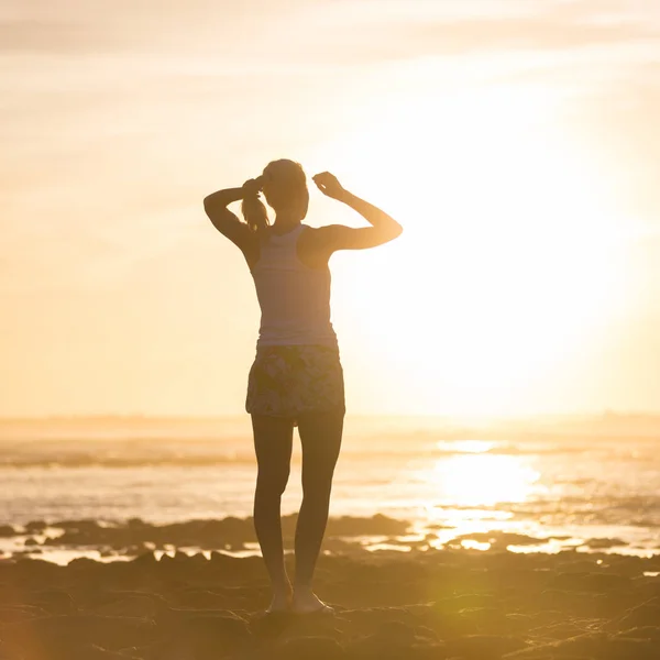 Vrouw op zandstrand kijken naar zonsondergang. — Stockfoto