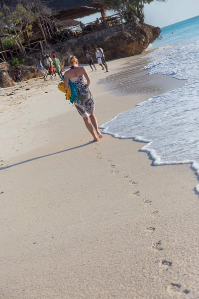 Mujer corriendo en la playa al atardecer . — Foto de Stock